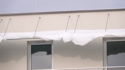 Dach nad balkonem poryty grubą warstwą śniegu © tomo81