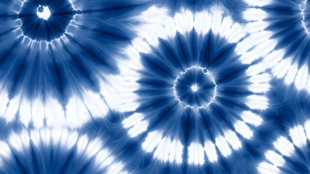 Indigo blue and white shibori tie dye spiral pattern. Traditional Japanese textile art and bohemian style. Seamless circular swirl designs repeating on a soft cotton fabric texture.