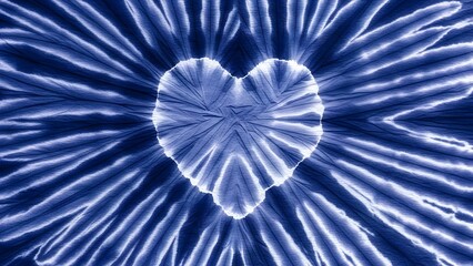 Blue indigo tie dye heart on a sunburst fabric texture. Romantic symbol and artisanal craft. White heart shape on a pleated shibori dyed background