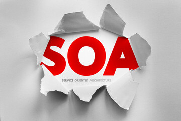 SOA stands for Service Oriented Architecture, revealed behind torn paper. It is a software design style where services are provided to other components via a communication protocol over a network