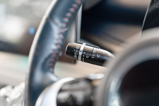 Close-up at car wheel handle lever for activate the raining wiper and turning lighting signal. Transportation and vehicle part equipment object, selective focus.