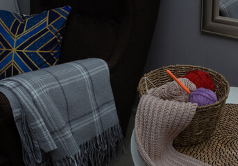 Knitted scarf with crochet hook on armchair