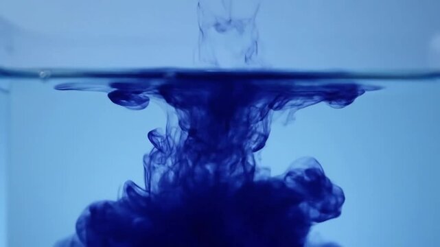 Gradual diffusion and settling of ink into a serene blue wash Medium shot, underwater perspective