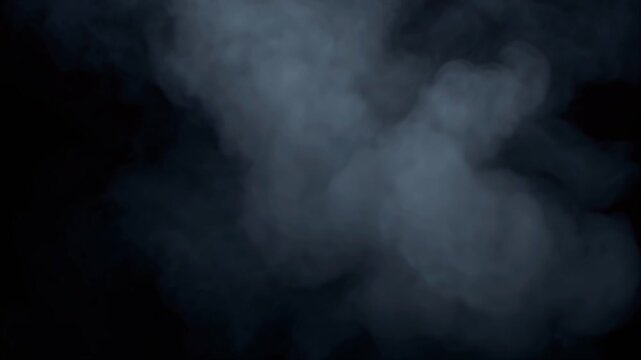 4K cinematic slow-motion video dense white smoke cloud suspended complete black background, smoke gradually breaking small glowing vapor fragments directional light fragment, micro-particles drifting
