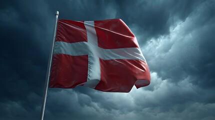 The Danish flag waving on a flagpole against a dramatic cloudy sky with stormy weather conditions and strong winds