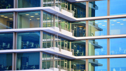 A modern tall building made of steel and glass, housing offices and financial institutions. Glass...