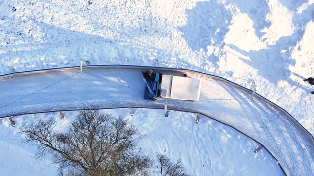 Ice fishing in a snowy landscape using a portable shelter and hole cover
