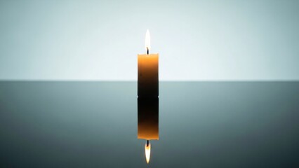 A single lit candle standing on reflective surface with soft gradient background