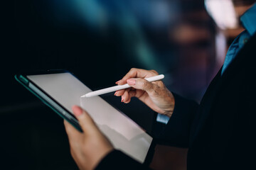 Close-up of senior woman&rsquo;s hands interacting with stylus and tablet. Concept of digital accuracy, seamless tech use, and touch precision in modern business work.