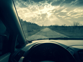 Naklejka premium inside the car. driver behind the wheel. drive a car. journey. bad roads. by car . steering wheel and dashboard. wheels and engine.