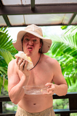 Scandinavian Tourist Man Eating Durian Outdoors with Tropical Leaves Background
