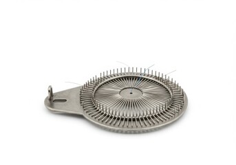 Naklejka premium Circular metal flower frog used in floral arrangements, featuring sharp upright pins to hold stems in place. 