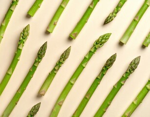 Healthy fresh green asparagus spears are carefully arranged in a beautiful diagonal pattern on a soft beige background, emphasizing their natural texture and vibrant appeal