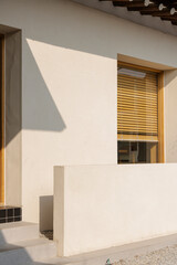Architectural facade featuring warm wooden blinds and a minimalist design bathed in soft, natural light.