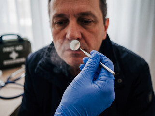 Paramedic hands holding small mirror to check breath first aid emergency medical help healthcare professional blue nitrile gloves clinic background copy space diagnostic