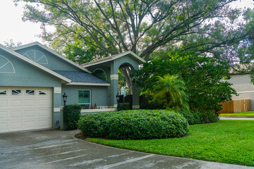 Fototapeta premium Peaceful neighborhood home surrounded by trees and foliage