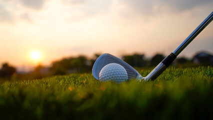 Obraz premium Golf clubs and balls on a green lawn in a beautiful golf course with morning sunshine.