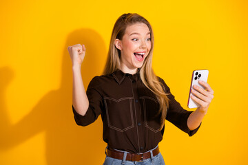 Happy young woman taking selfie in bright yellow background expressing joy fashion lifestyle and...