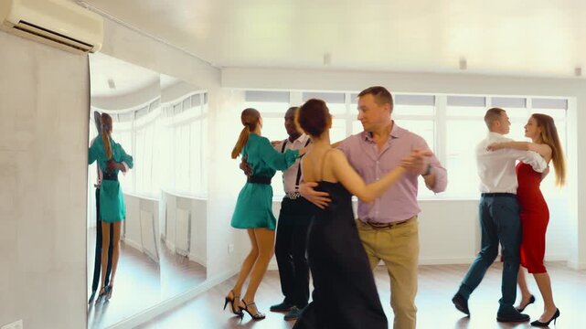 Couple of adult man and adult woman dancing waltz in studio 