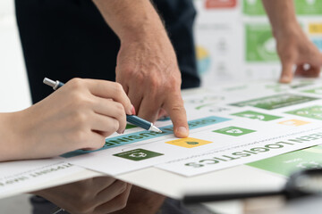 A diverse business team analyzing environmental charts and graphs in a collaborative meeting to create sustainable strategies in a modern office.