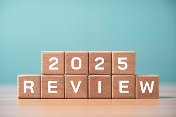 2025 business review concept with wooden blocks spelling review and year representing annual performance summary, business analysis to strategic planning and corporate year end report.