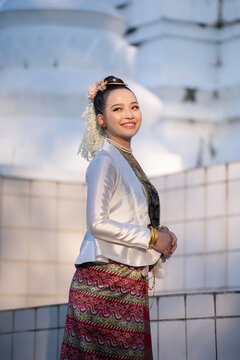 Portraits smiling woman wearing elegant cultural attire with floral hair accessories and jewelry. Burmese traditional dress