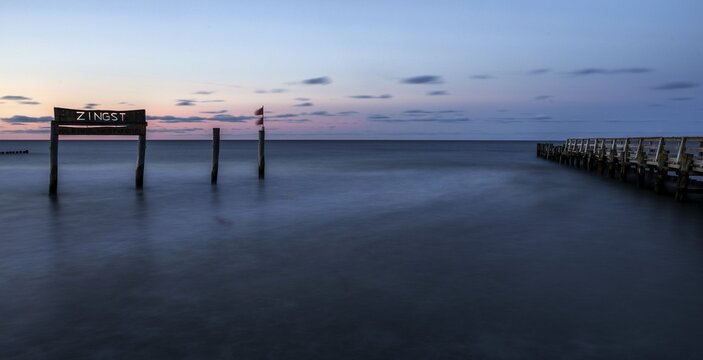 Wooden sign in the sea with inscription Zingst and wooden walkway, long exposure, evening light, Zingst, Fischland-Dar&szlig;-Zingst, Western Pomerania National Park, Mecklenburg-Western Pomerania, Germany