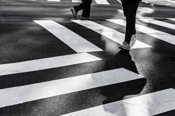 Pedestrians Crossing Zebra Crossing with Shadows on Urban Street