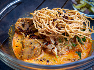 Khao Soi Beef Close-up: Northern Thai Curry Noodle Soup Braised Beef Crispy Fried Noodles Coconut Detail
