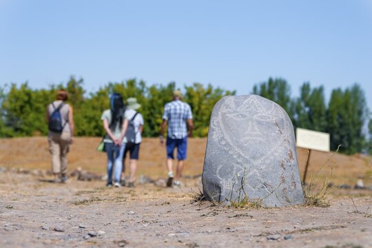 Tourists, Balbals, historical gravestones in the shape of human faces, near Tokmok, Chuy, Kyrgyzstan