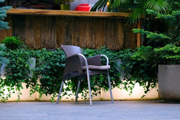 open air patio restaurant exterior furniture chair in surrounding of decorative plants neon light counter background design style object