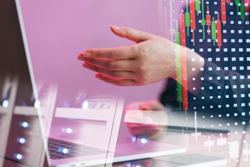 Hands interacting with a laptop while displaying financial data on screen in a business setting