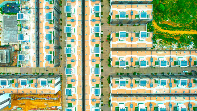 aerial drone shot straight down over identical houses with solar panes on roof and neat orderly roads in between near dwarka expressway gurgaon delhi