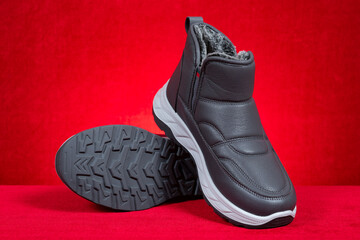 pair of grey insulated sneakers for boy or man on red