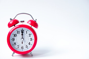 The classic red alarm clock is isolated on a white background