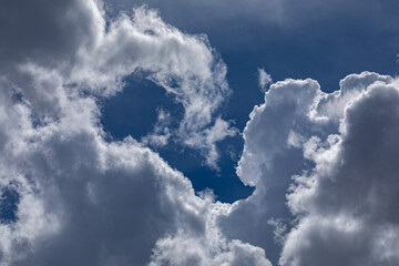 accumuli di nuvole cariche di pioggia nel cielo azzurro, di giorno, in estate