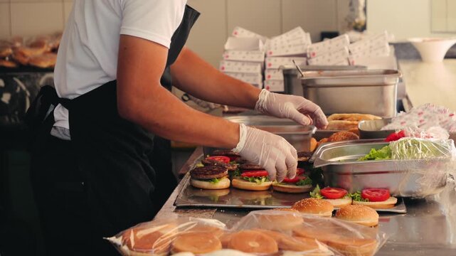 Chefs prepare burgers, food in an open kitchen for a large group. Charity lunch concept, humanitarian aid. High quality 4k footage