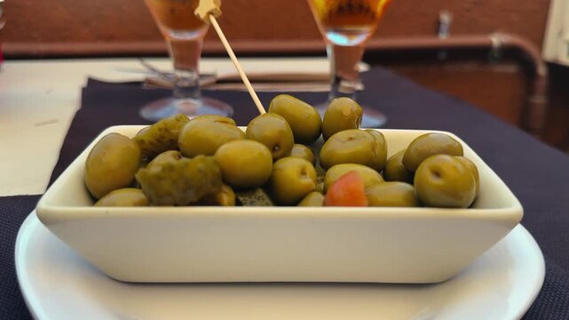 Juicy green olives with beer on a table at a street cafe terrace. Tapas an appetizer before the main course. . High quality 4k footage
