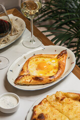 Traditional Georgian dinner with adjarian and megreli khachapuri khinkali dumplings and wine served on restaurant table