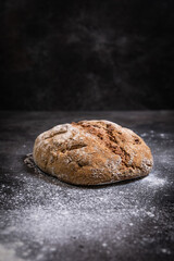 Rustic Homemade Bread On Dark Slate Countertop With Flour
