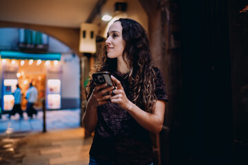 Young woman glancing aside while holding smartphone, expressing awareness, distraction or curiosity in urban environment, blending digital presence and real-world focus.