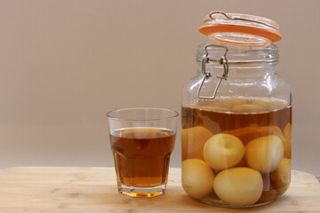 Jar of pickled eggs and glass of vinegar in kitchen