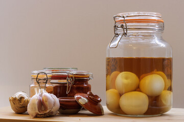 Jar of homemade pickled eggs next to glass pots and garlic