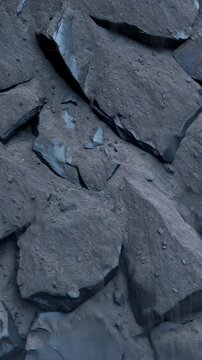 Overhead view of gray rocks collapsing, a dramatic rockfall and debris sliding down, mining industry concept footage Vertical video