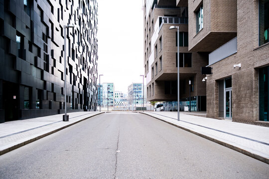 Empty city street avenue canyon between modern urban architecture with strong perspective and symmetry creating clean downtown background for design