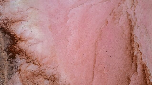 Aerial view of a striking pink lake creates a surreal landscape, its waters stained with life amid the stark Australian outback, Yallabatharra, Western Australia, Australia.