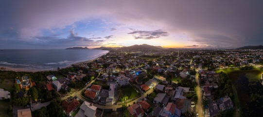 Aerial panorama of the Atlantic ocean coast and calm green neighborhood near the city of Florianopolis in Brazil