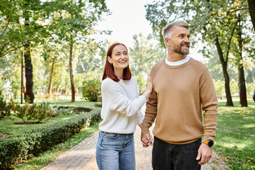 Obraz premium Couple enjoying a sunny spring stroll in a vibrant green park