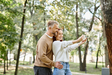 Obraz premium Couple enjoys a joyful walk and captures memories in a spring park setting