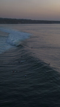 Aerial view of the ocean's dark waves curling gently under a soft, pastel sky, Bali, Bali, Indonesia.